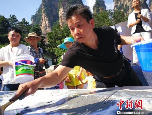 土家族画家创作百米砂石画长卷绘制张家界风光
