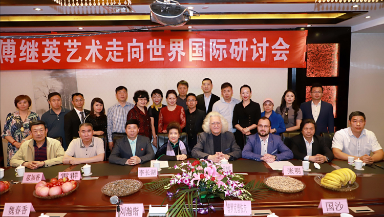 配图4：参加交流会的全体嘉宾在条幅“傅继英艺术走向世界研讨会”下的合影照。