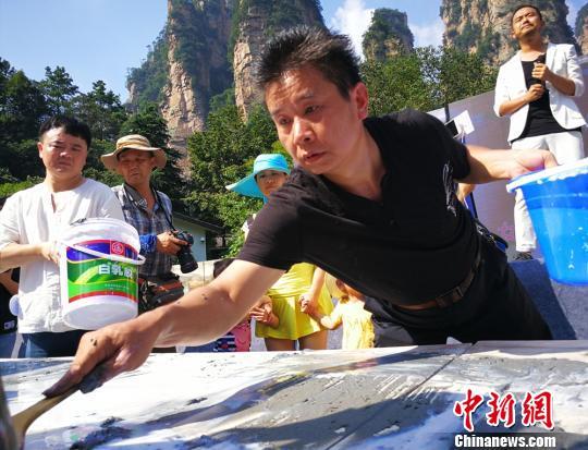 土家族画家创作百米砂石画长卷绘制张家界风光