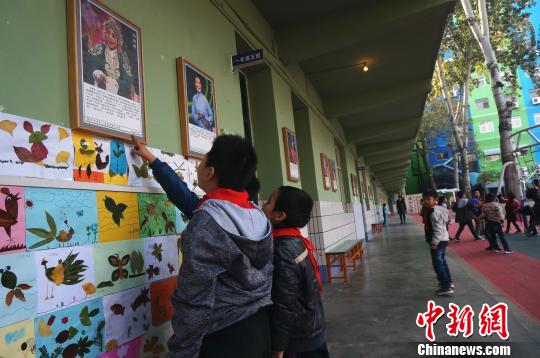 图为学校教学楼走廊上悬挂的戏曲名家画像。　韩章云 摄